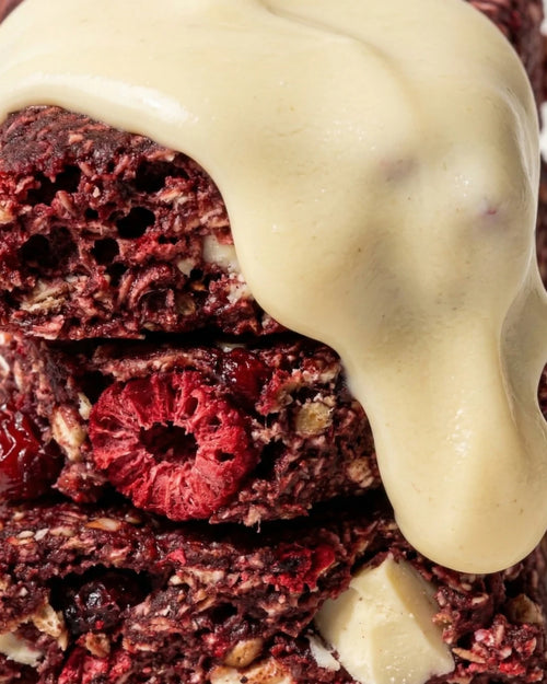 Cross-section of a Berries n' White Choc bar with white chocolate melting over fresh raspberries