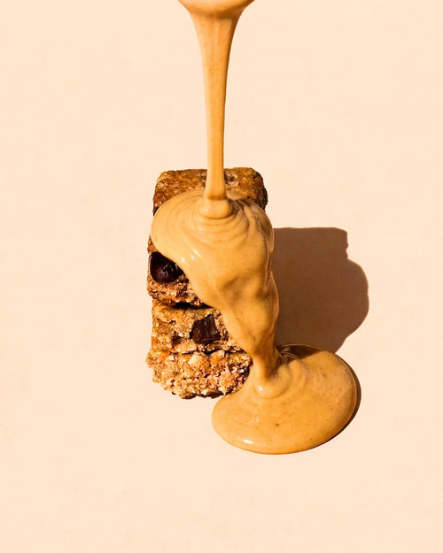 Crunchy Choc Chip oat and nut butter bar drizzled with nut butter, showing its crunchy oat texture