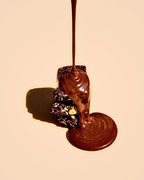 Cross-section of a Fudgy Choc n' Hazelnut bar drizzled with melted chocolate, showing roasted hazelnut pieces