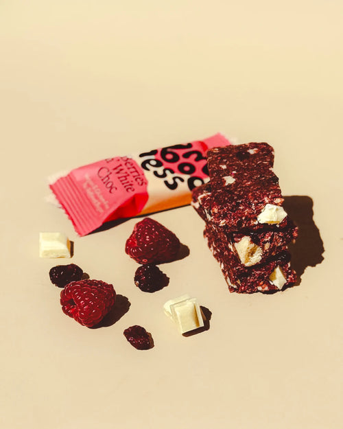 Berries n' White Choc snack bar with its wrapper, fresh raspberries, and white chocolate chunks